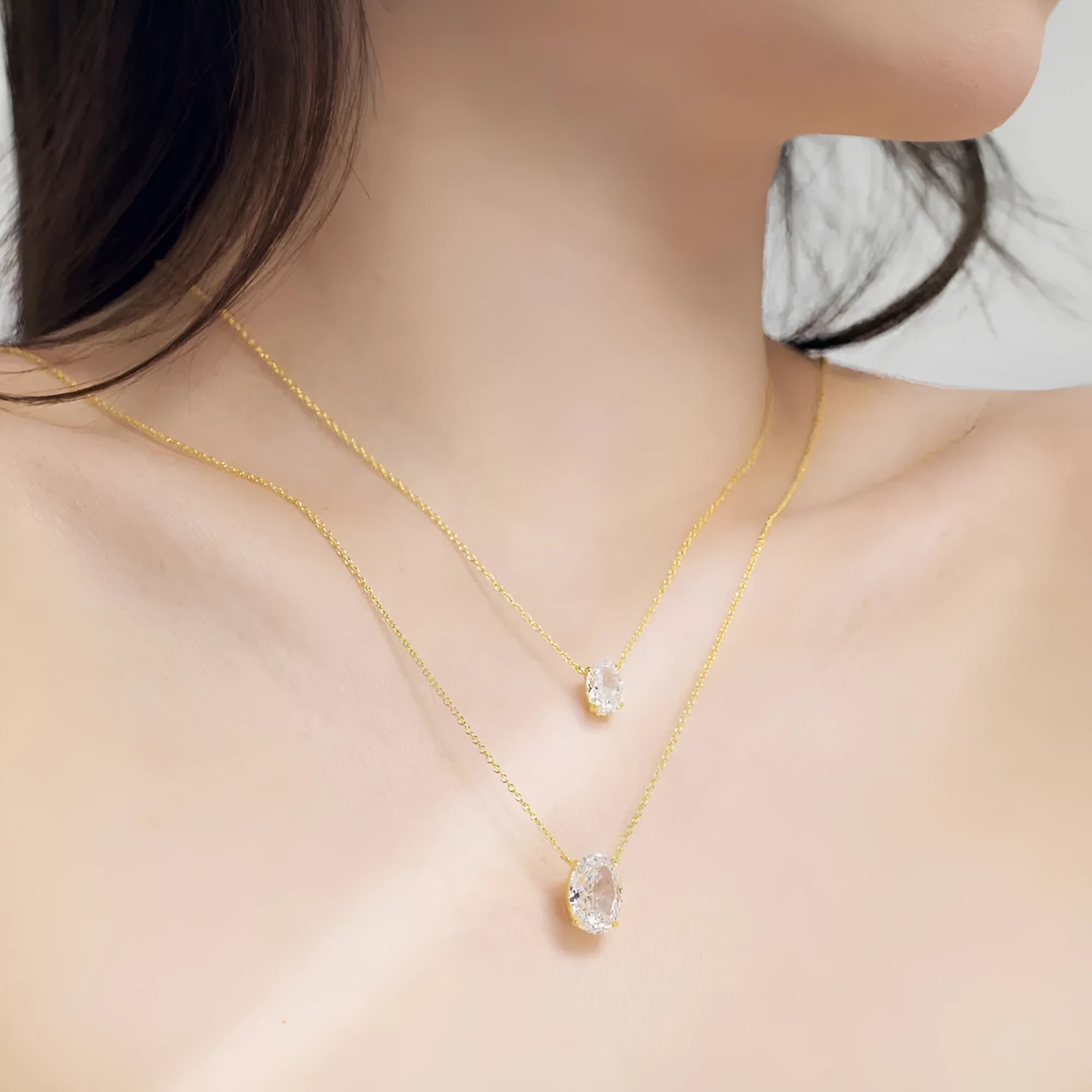Close-up of a women's oval ice flower pendant sterling silver necklace on a chain.