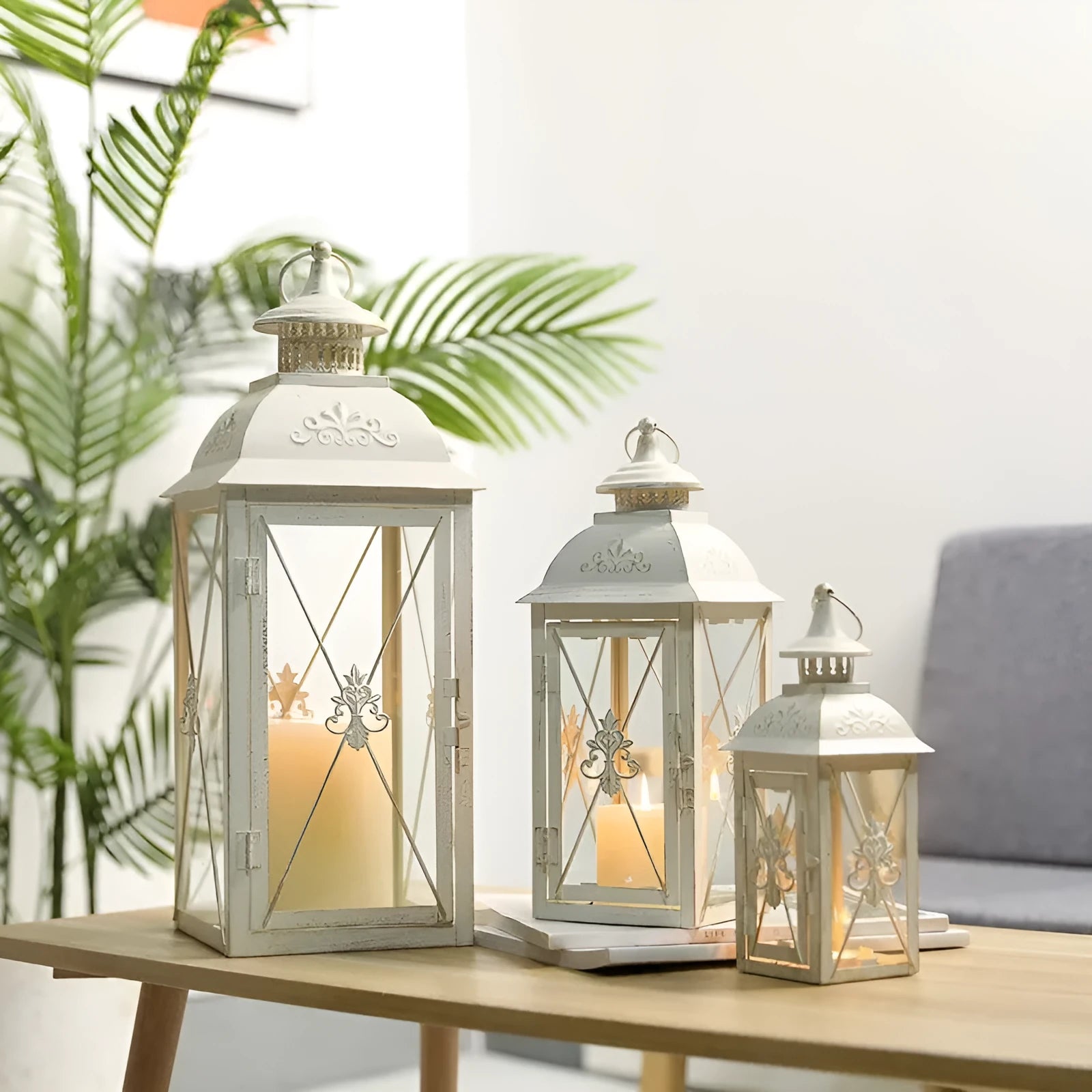 Black and white wrought iron floor standing storm lantern with tempered glass panels on a patio.