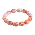 Natural cherry agate barrel bead bracelet with Ruyi symbol on a wrist.