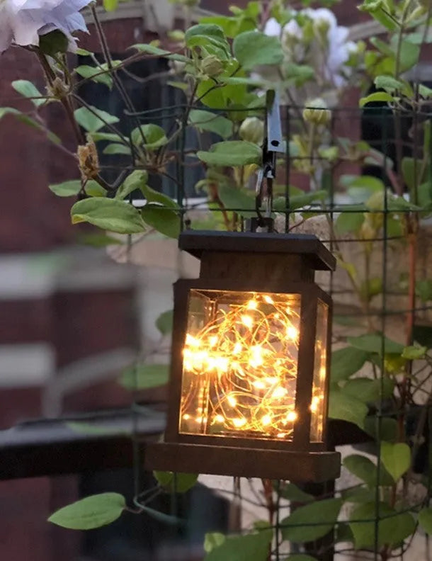 Black solar wind lamp with warm white LED light on outdoor table
