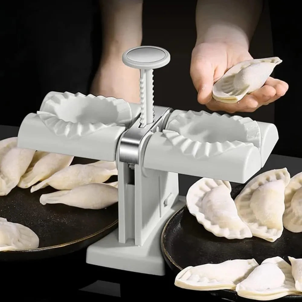 White double head manual dumpling press mould with anti-slip rubber base on kitchen counter.