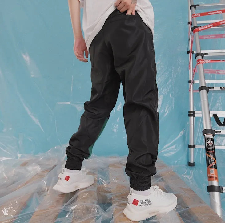 Green Japanese hip hop sweatpants with hit colour stitching, letter print, and bouquet floral design on a low-waist drawstring style