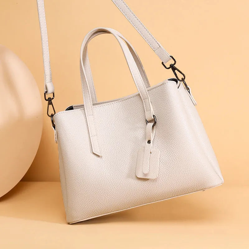 Women's cowhide leather shoulder handbag in horizontal square shape with tassel details and organised interior compartments