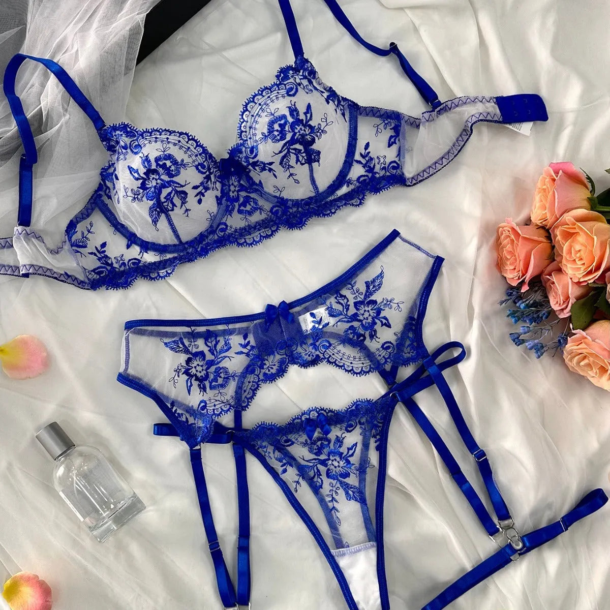 Women's embroidered underwear set with see-through mesh cutouts and matching garters in sapphire blue.