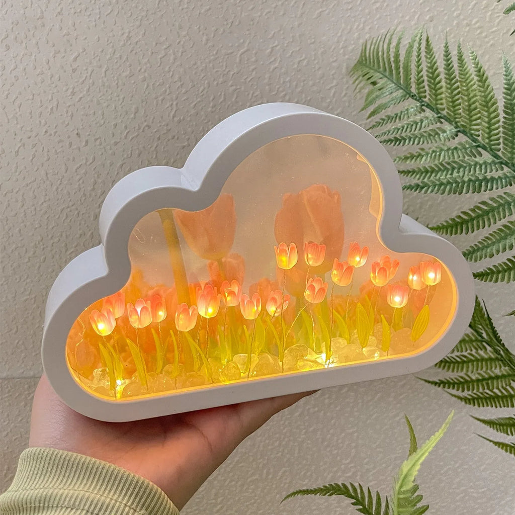 Assembled pink tulip-shaped night lamp with LED light, mirror front, and small photo frame on a desk.
