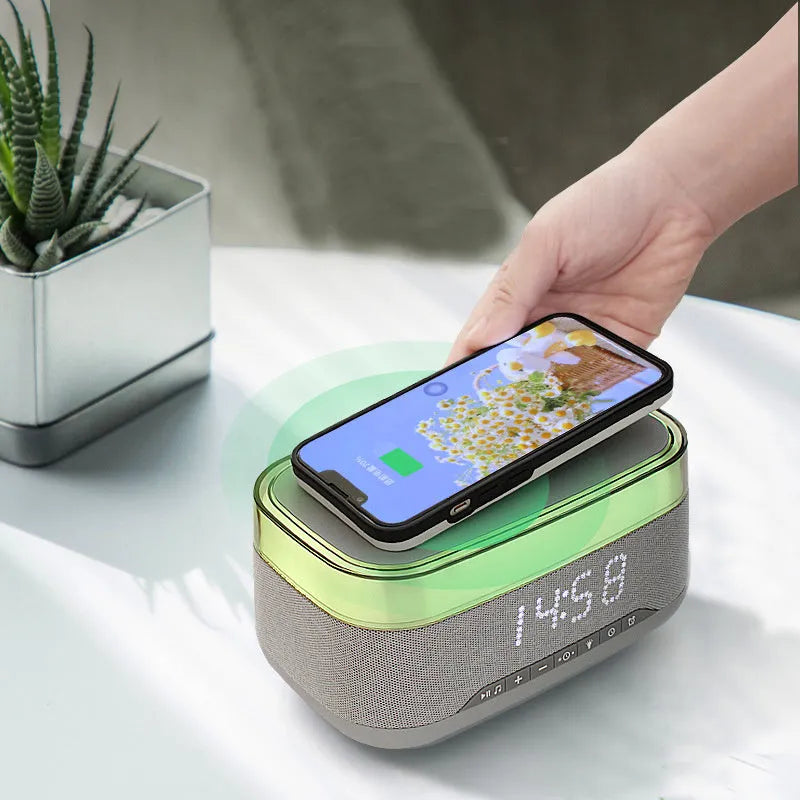 White multifunctional alarm clock with Bluetooth speaker and wireless charging pad on a table