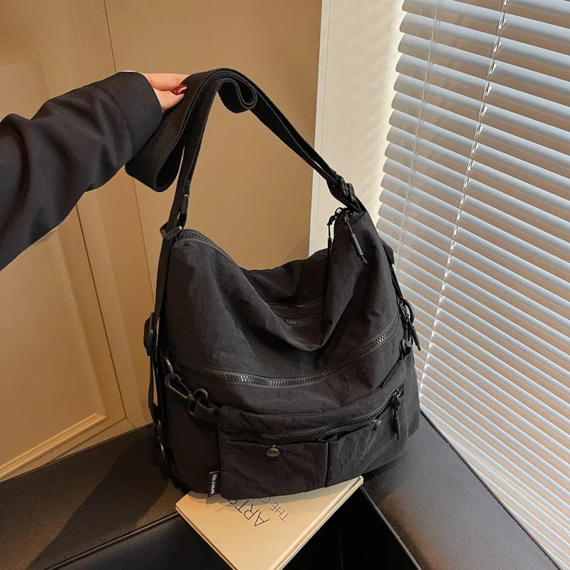 Women's nylon crossbody bag in square vertical shape with double shoulder straps and organised interior compartments