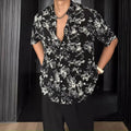 Loose-fitting floral print short sleeve shirt cardigan in black, laid flat.