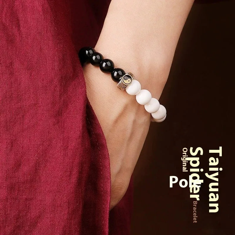 Black and white obsidian bracelet with Tai Chi symbol and mantra text on geometric beads.