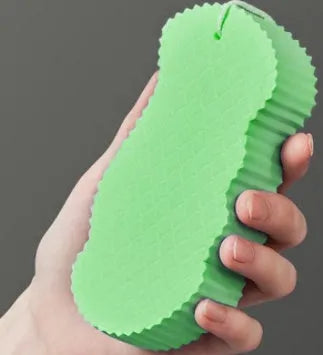 White 3D bath sponge with fish scale pattern for gentle body exfoliation in shower.