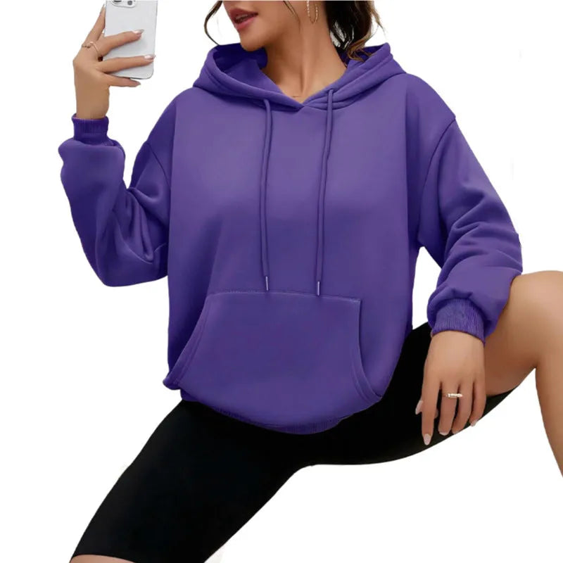 Women's loose fit grey hooded sweatshirt with front pocket and long sleeves on a hanger.