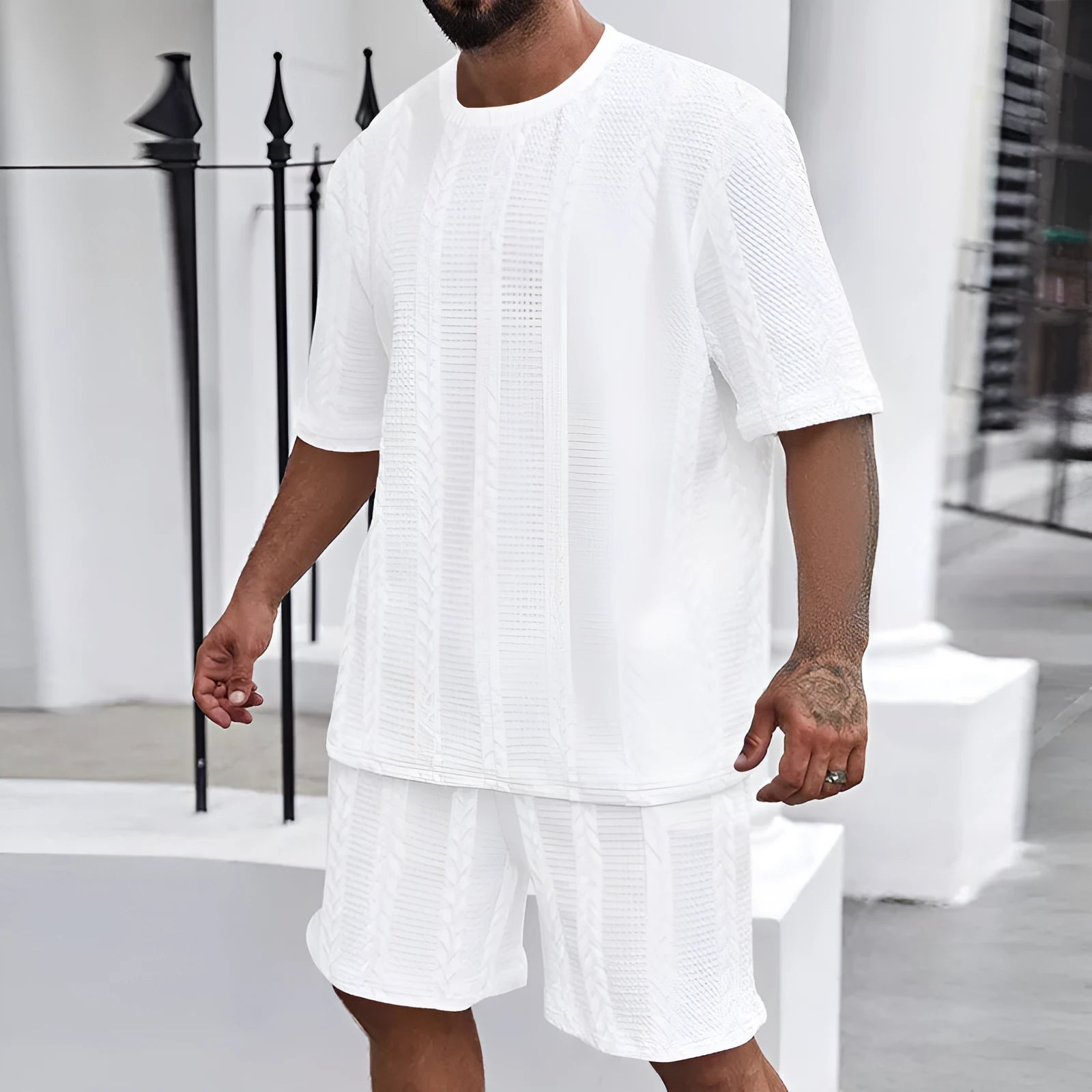 Knitted solid colour short sleeve pullover and matching shorts laid flat.
