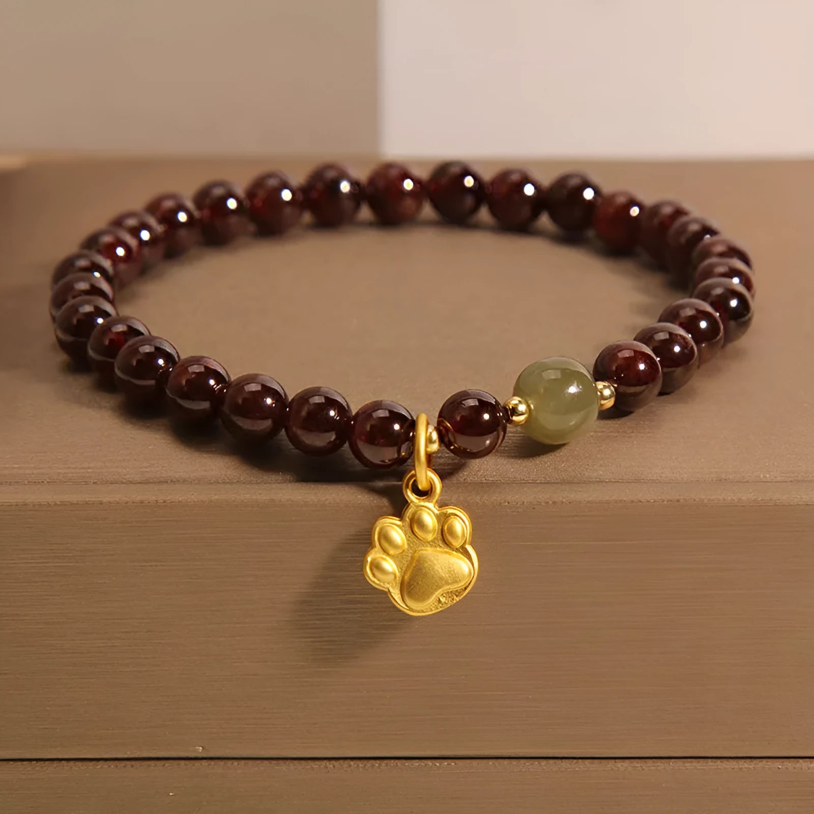 Cat's paw garnet crystal bracelet for women showing clear beads with feline charm