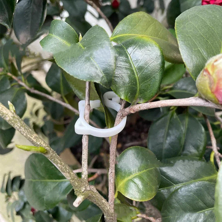 Colourful cat-shaped plastic plant clip for garden use on a white background.