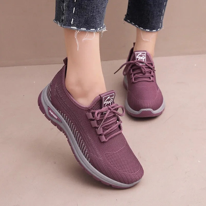 Women's black mesh sneakers with round toe, cross-strap details, and lace-up front on rubber sole