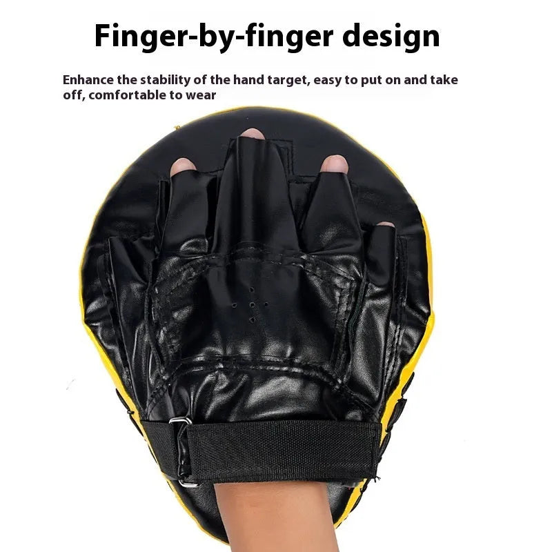 Red and black curved boxing punch mitts held in a trainer's hands for Muay Thai or Sanda practice.