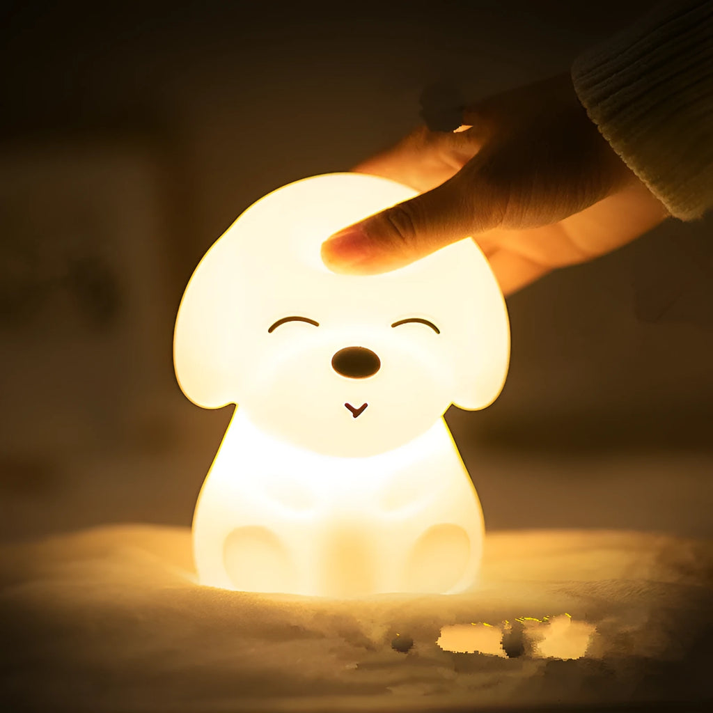 White silicone puppy-shaped LED night light with soft glow on a flat surface