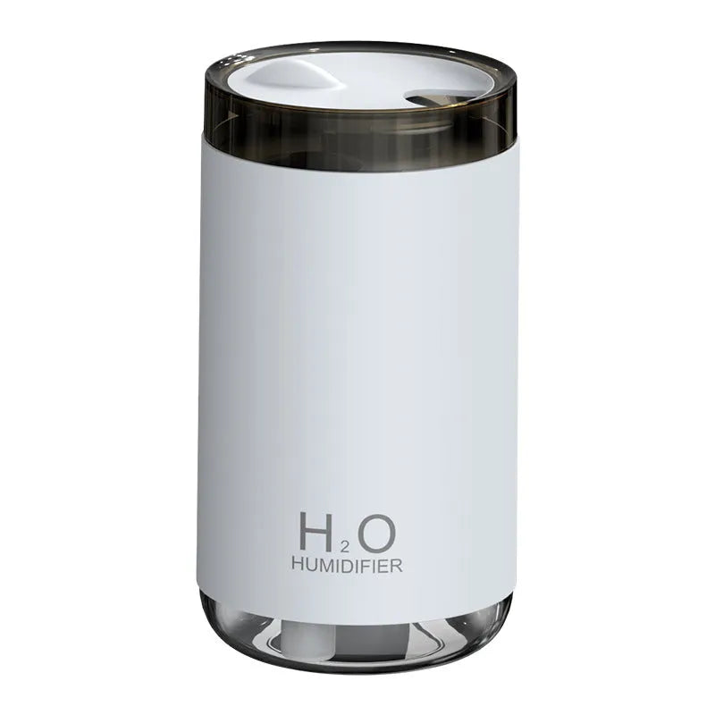 White USB jellyfish smoke ring humidifier with warm night light on a table, showing nano mist.