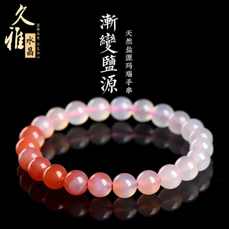 Natural gradient Yanyuan agate bracelet with geometric cut beads on a wrist.