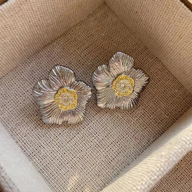 Copper stud earrings with textured gardenia flower design and two-tone electroplated finish.