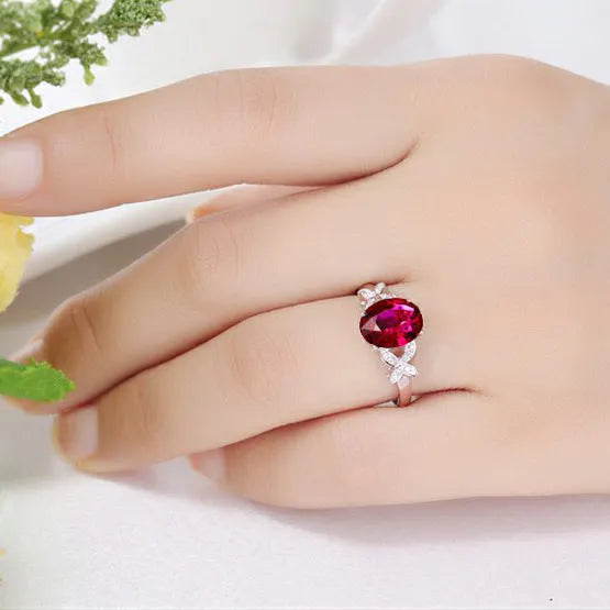 Women's copper butterfly ring with heart shape and rose gold finish showing red gemstone accent option