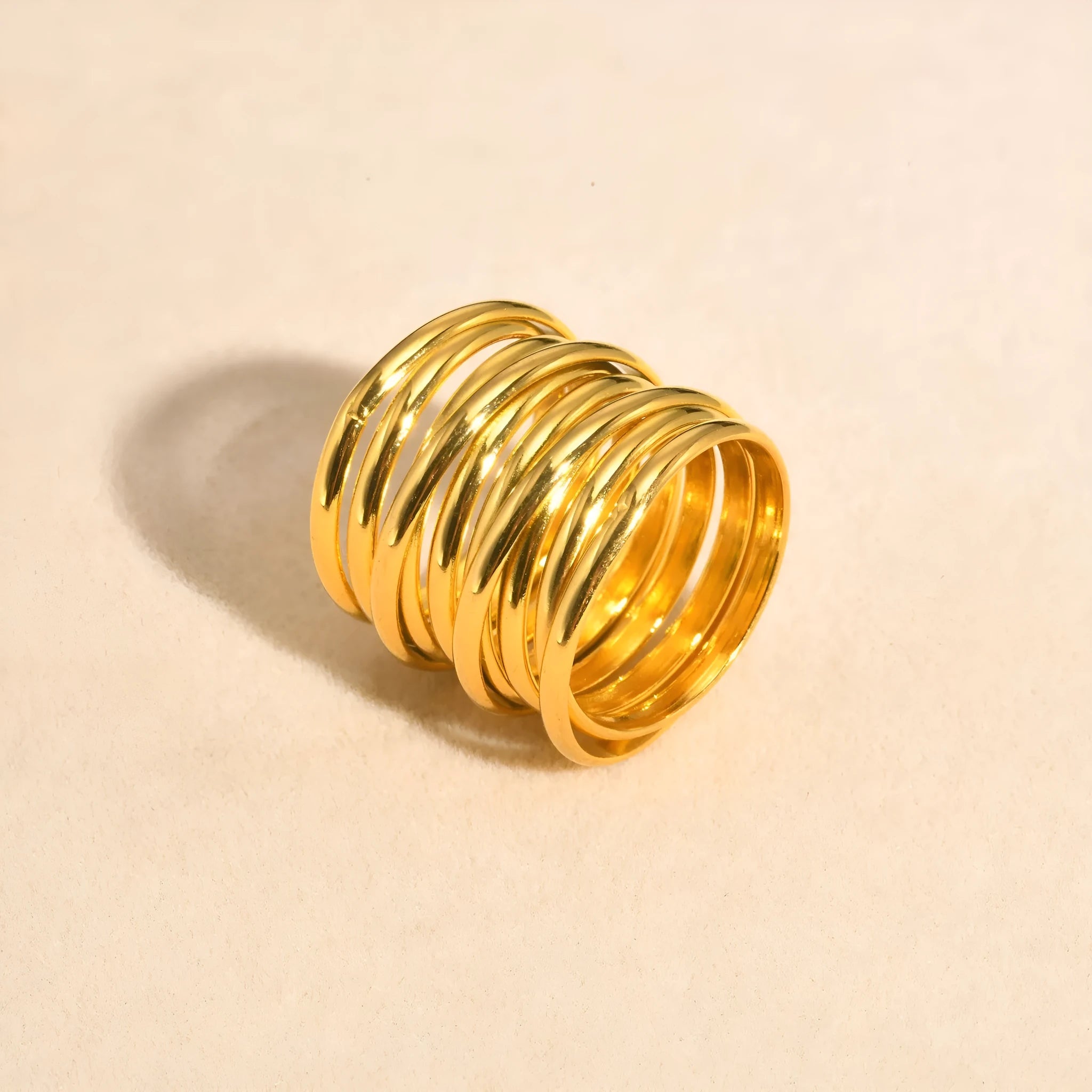 Gold electroplated stainless steel multi-loop multi-layer ring on white background in US size 7