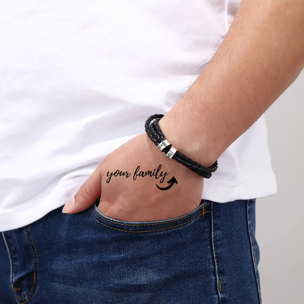 Personalised mens braided genuine leather bracelet in black with custom stainless steel name beads showing engraved names