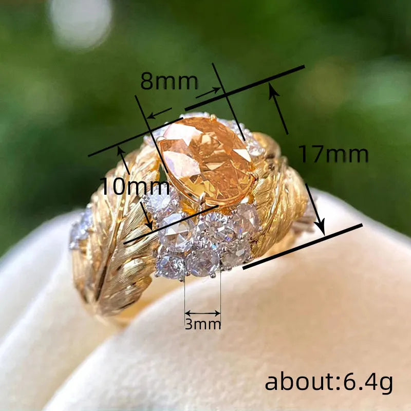 Gold-coloured embossed feather ring with geometric shape and inlaid yellow zircon stone