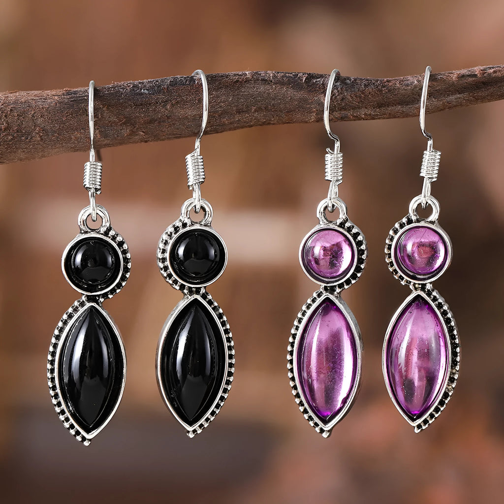 A pair of vintage geometric drop earrings with a round gemstone, in black and purple electroplated zinc alloy.