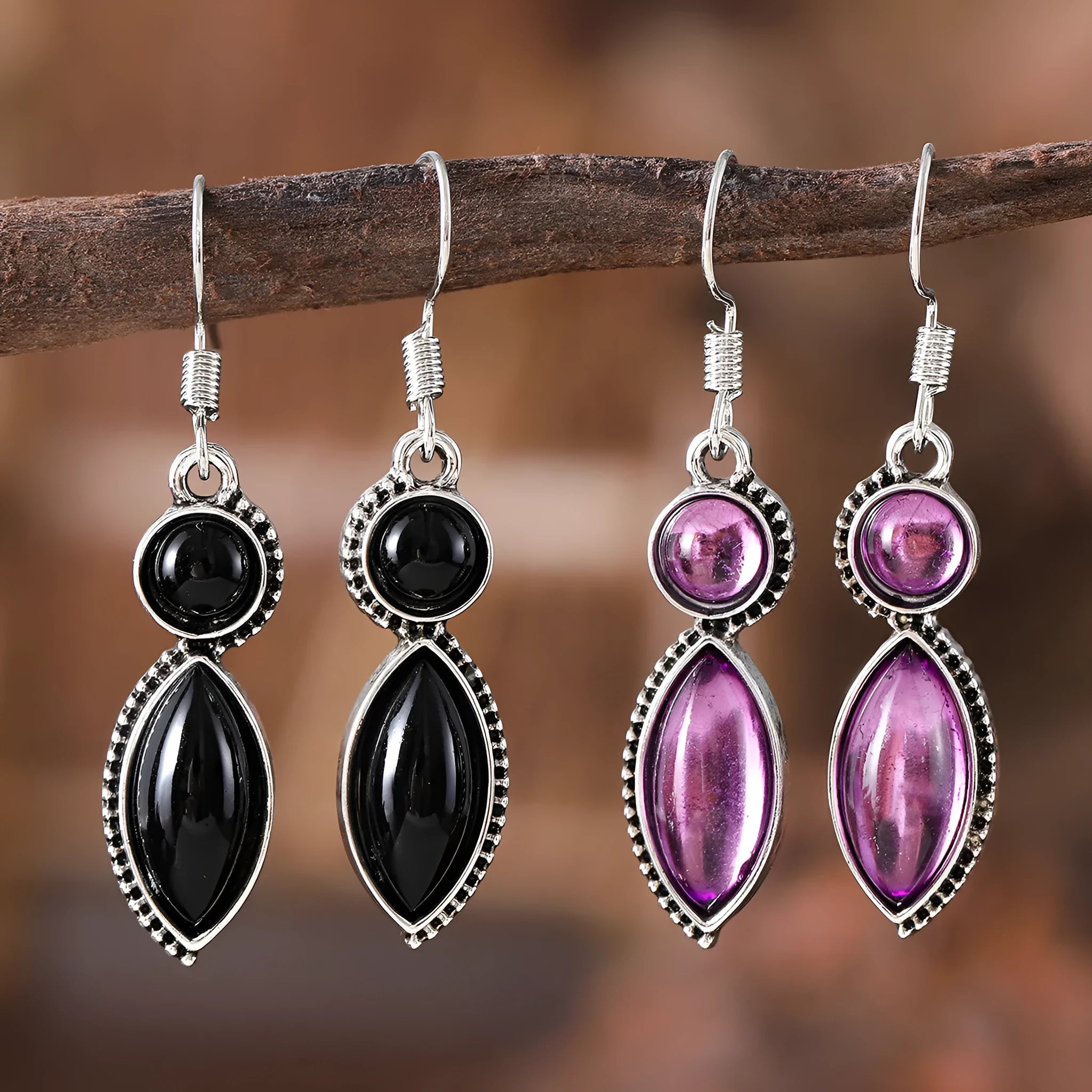 A pair of vintage geometric drop earrings with a round gemstone, in black and purple electroplated zinc alloy.
