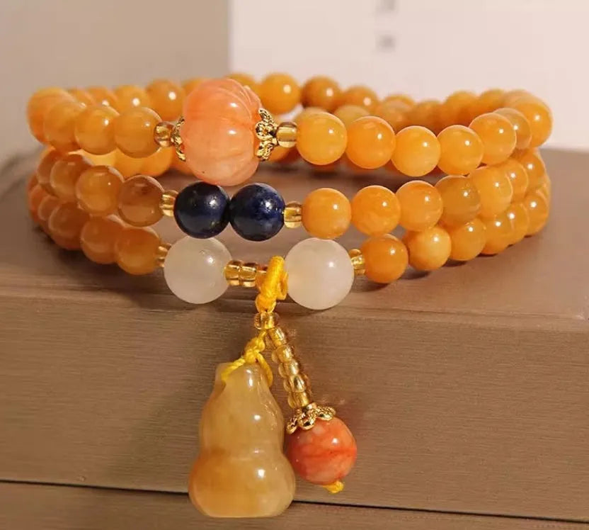Women's multi-circle bracelet with three strands of natural Jinsi Jade beads and a resin flower calabash pendant on a white background