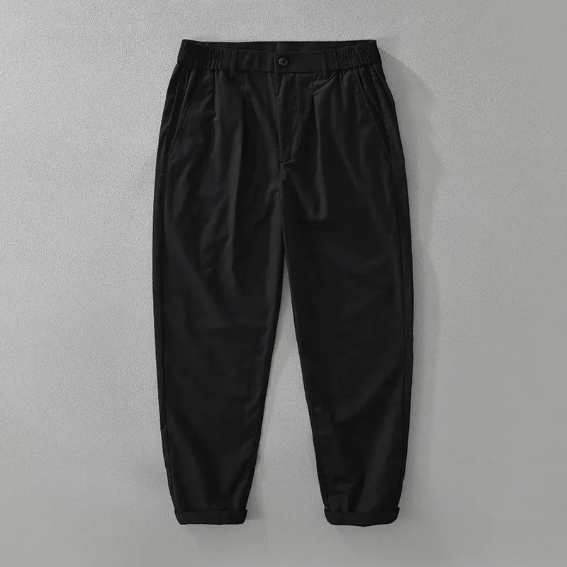 Man wearing loose fit brown cotton linen straight-leg trousers with a casual top.