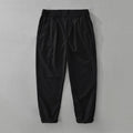 Man wearing loose fit brown cotton linen straight-leg trousers with a casual top.