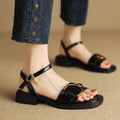 Women's black thick-soled leather sandals with a round toe and button closure on a white background.