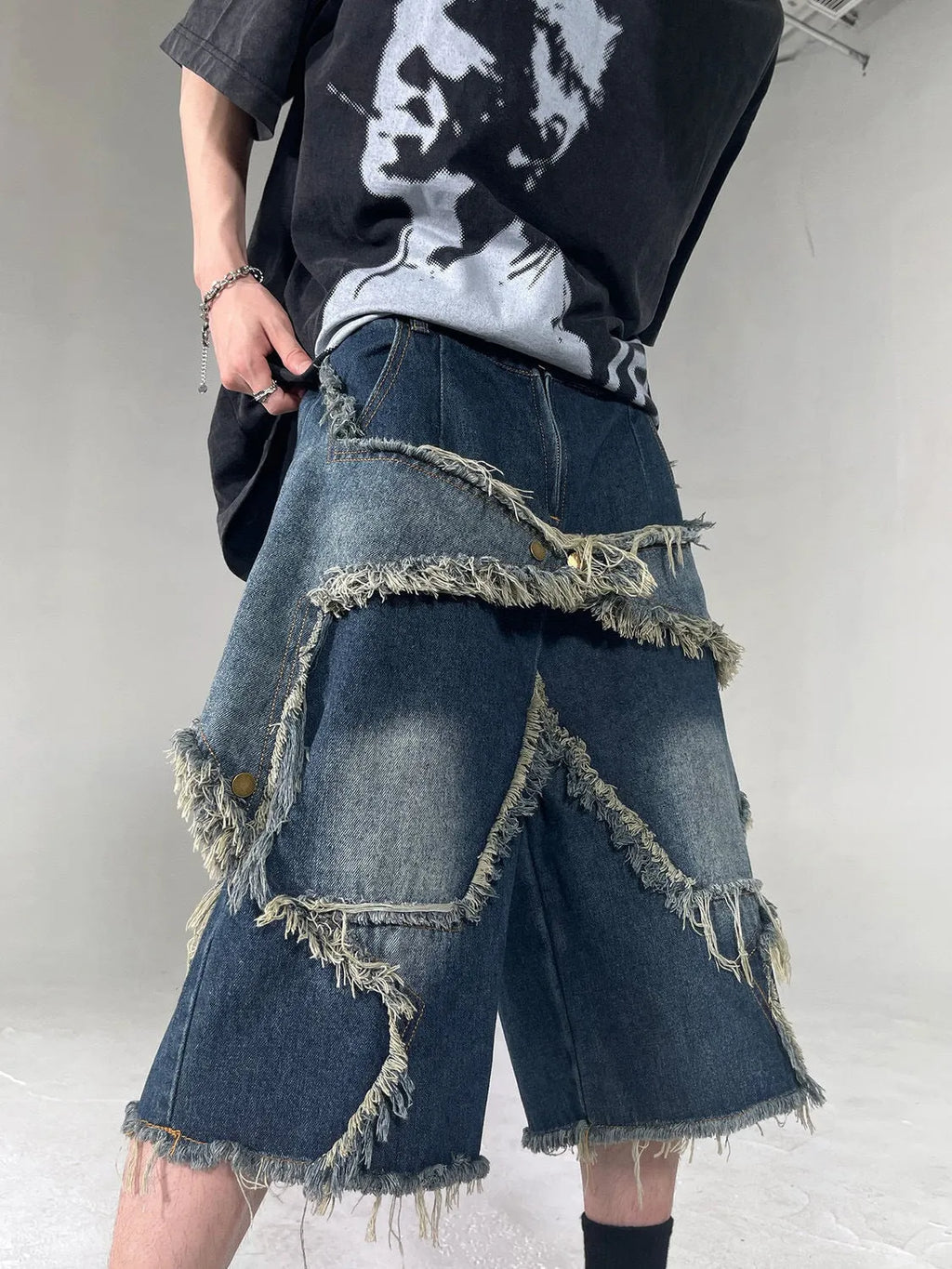 Blue men's loose-fit denim shorts with a frayed five-pointed star design on the leg.