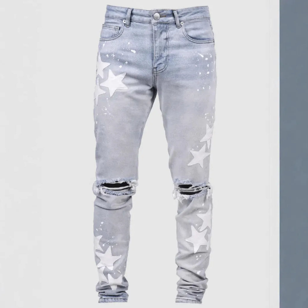 Men's slim blue jeans with embroidery detail on the leg, showing a mid-waist fit.