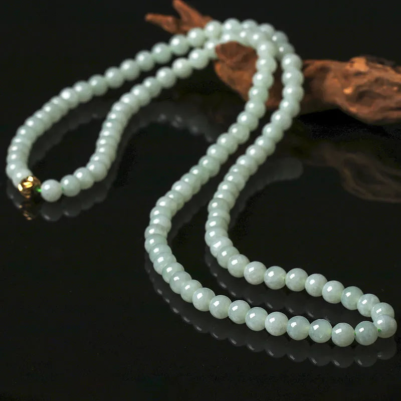 Adjustable length natural jade bead necklace with white and green round beads on a chain.