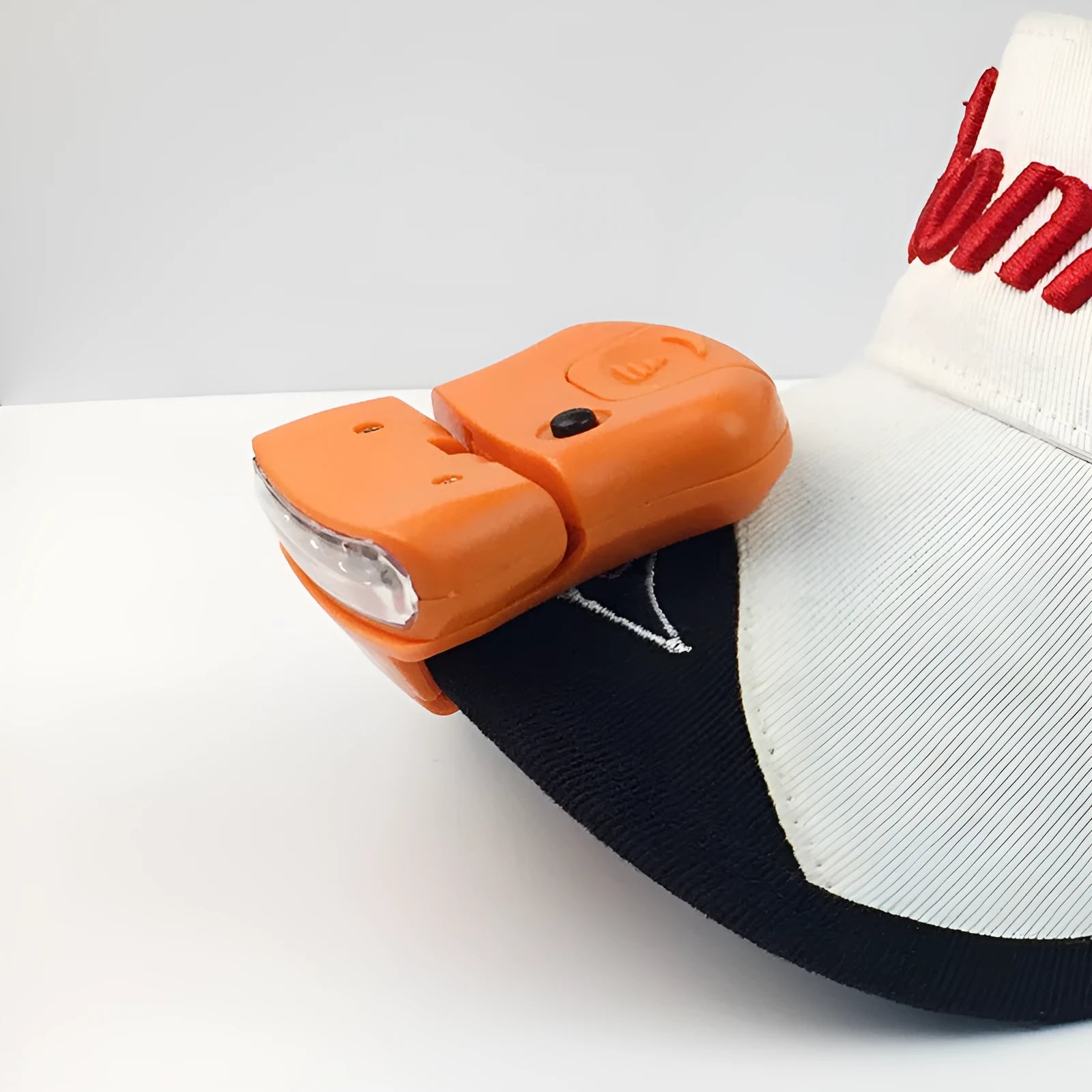 5LED ABS plastic cap lamp clipped to a cap brim, measuring 5x4.5cm, available in black or orange for outdoor use