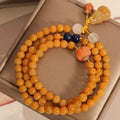 Women's multi-circle bracelet with three strands of natural Jinsi Jade beads and a resin flower calabash pendant on a white background