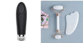 White jade facial roller and gua sha scraping tool set presented on a wooden board.