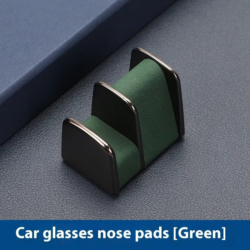 Zinc alloy and leather car dashboard glasses clip holder in green, shown on a car dashboard.