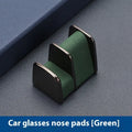 Zinc alloy and leather car dashboard glasses clip holder in green, shown on a car dashboard.