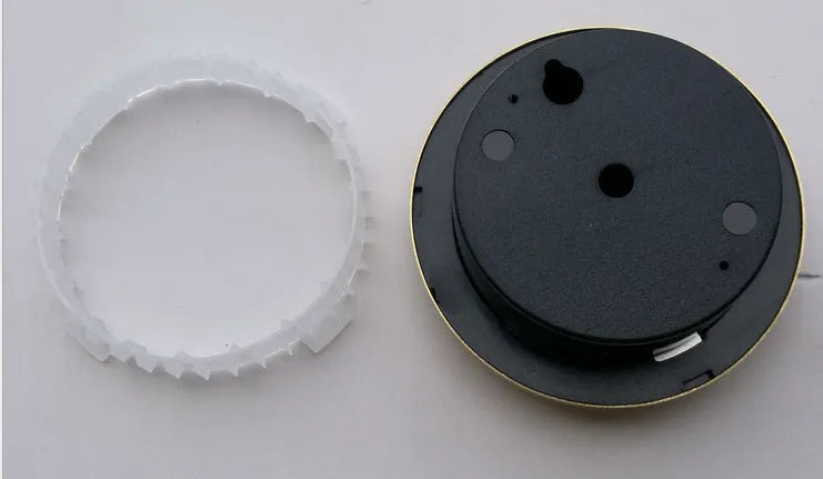 Analog thermometer and hygrometer with aluminium dial and outer ring on a white background.