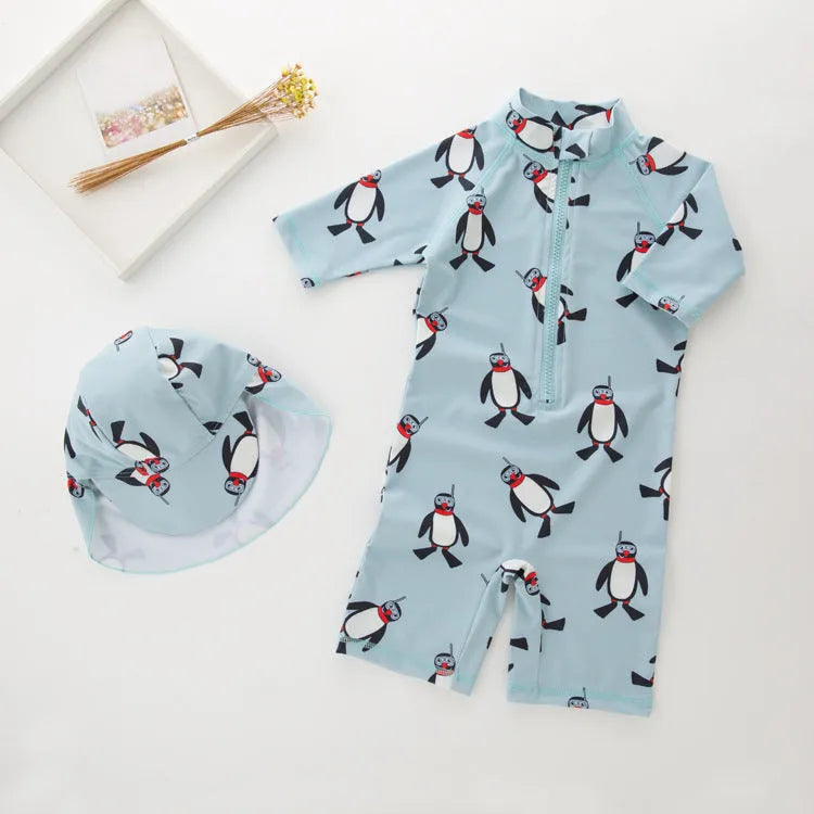 Boy's long sleeve penguin print swimsuit and matching swim cap set on a white background