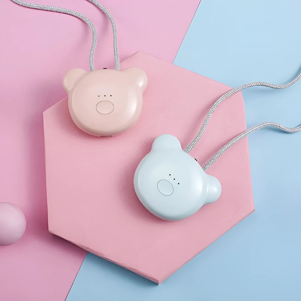 Compact pink USB portable air purifier necklace on a table with charging cable.