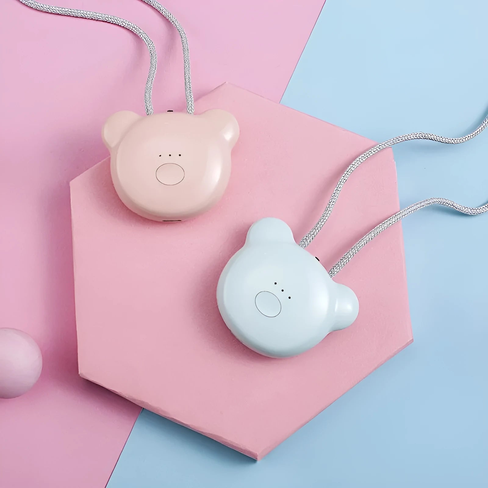 Compact pink USB portable air purifier necklace on a table with charging cable.