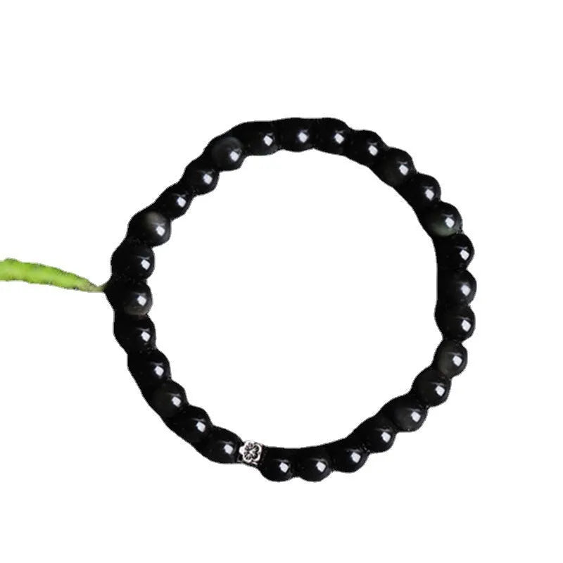 Natural obsidian bracelet with S925 sterling silver flower accessories on a wrist
