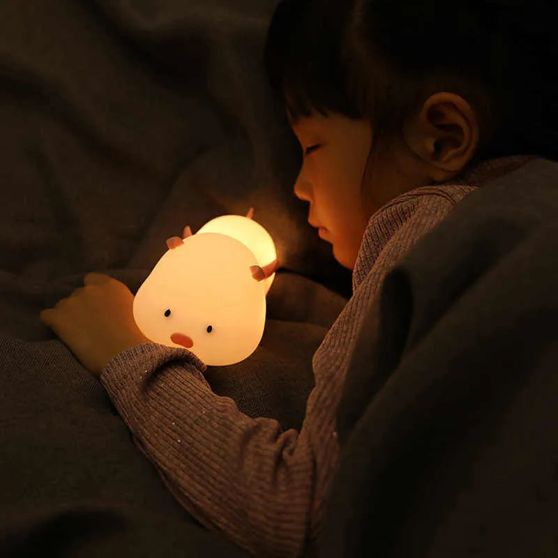 Blue silicone pig-shaped night light with USB charging port
