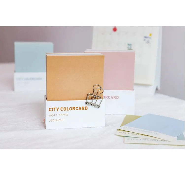 Set of rectangular paper memo notecards in four colour styles, shown with a pen, next to the OPP storage bag.