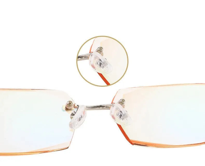 Diamond-cut metal reading glasses with tan frame and black lenses on a plain background